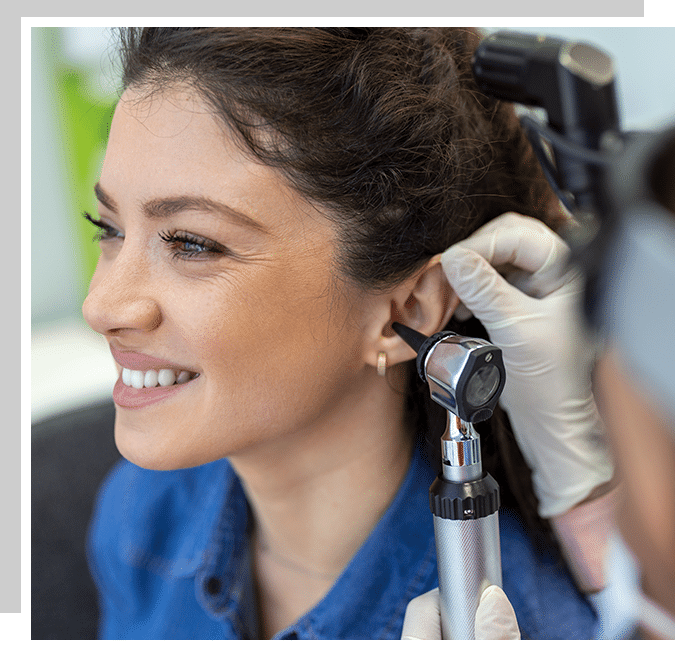 Woman getting her ears examined by an audiologist checking if she has impacted earwax